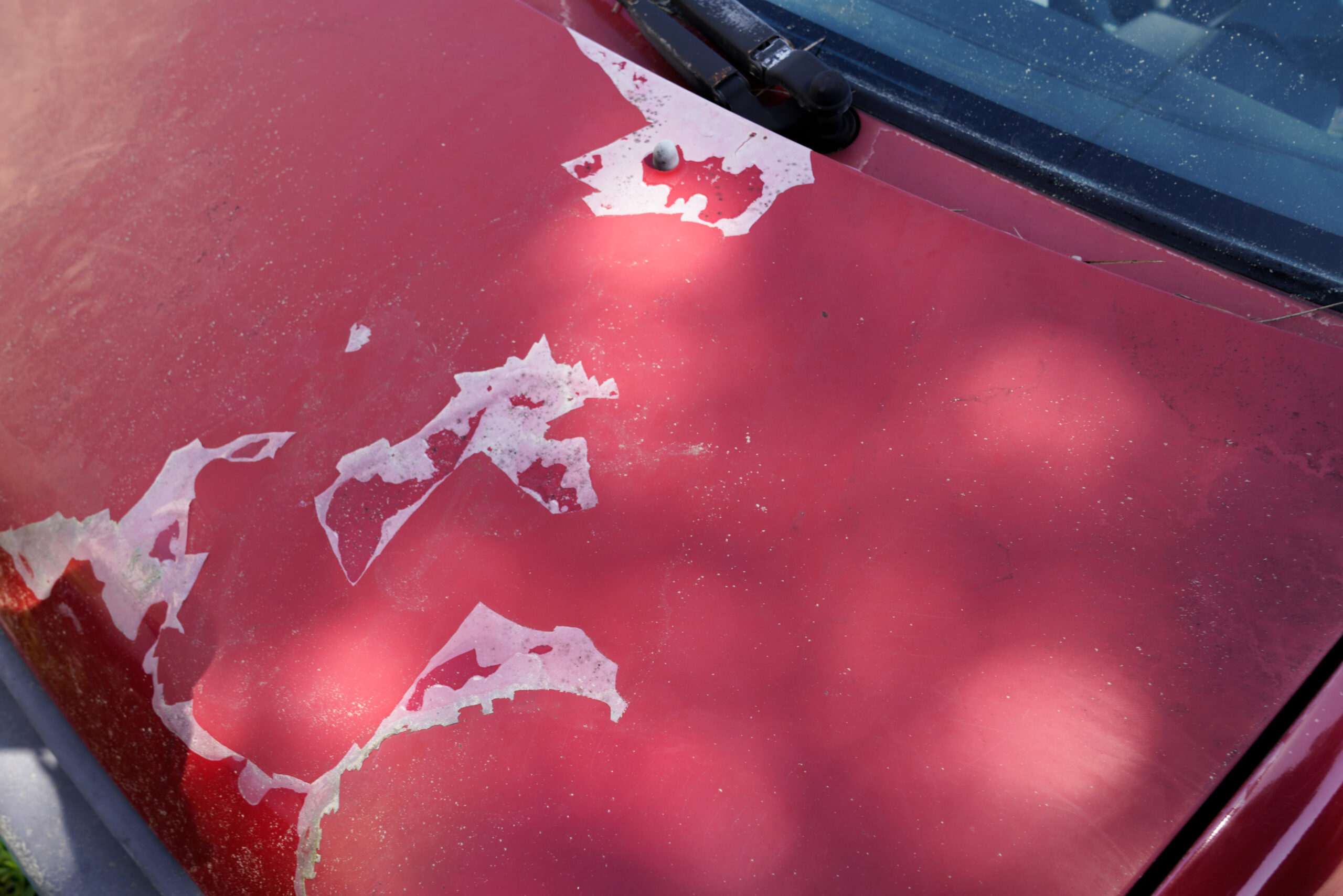 old car engine hood red used paint faded grunge on front bonnet